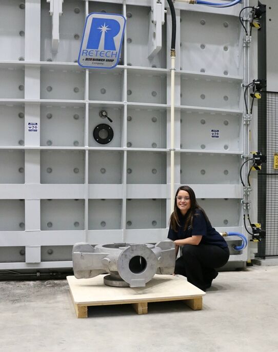 Engineer posing with ceramic shell titanium casting