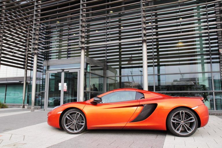 Orange car in front of building
