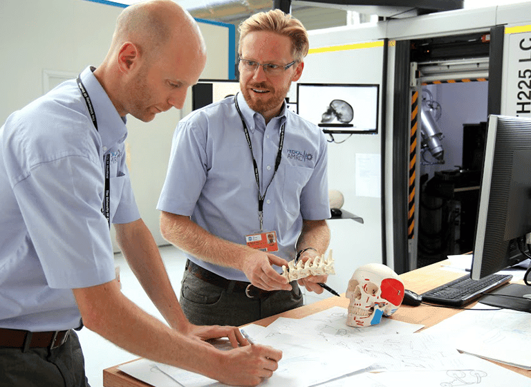 Two HVMC employees solving a problem together at a desk