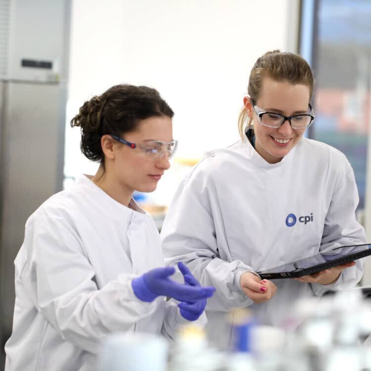 Two female engineers in lab coats in the lab