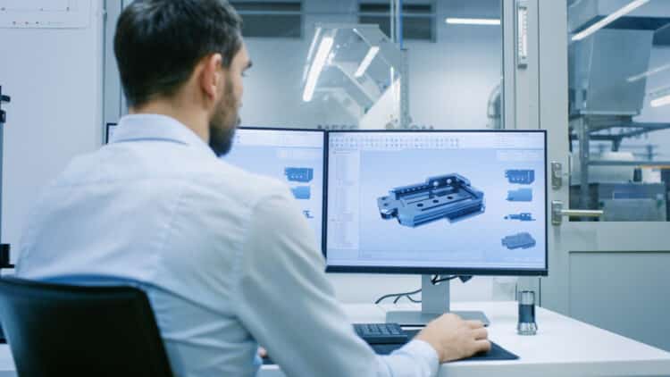 Engineer/ Technician Working on a Personal Computer with Two Displays
