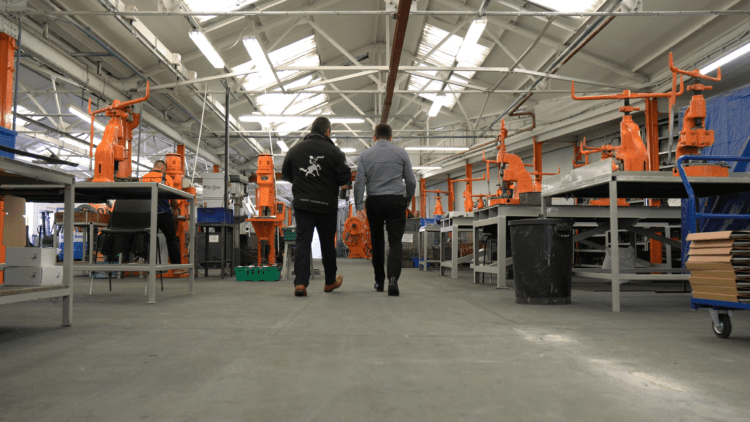 Two people walking through a manufacturing facility