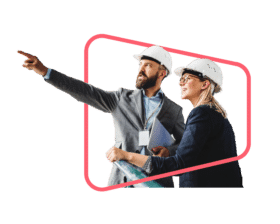 Two manufacturing SME employees wearing hard hats discuss an issue