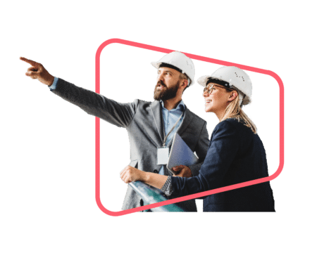 Two manufacturing SME employees wearing hard hats discuss an issue