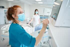 Physicians assessing condition of patient well-being in the intensive care unit