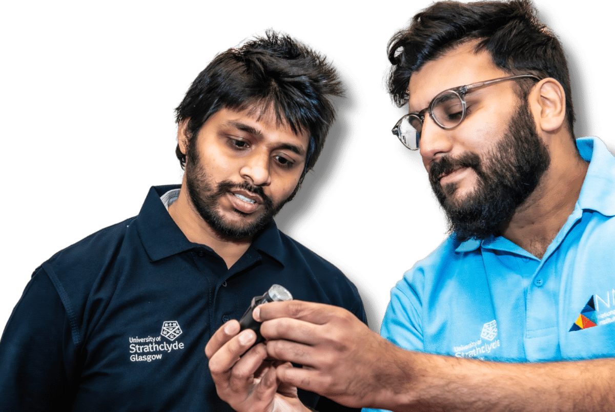 Two NMIS engineers looking closely at an object.